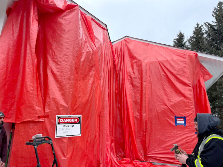 Tarp around a home Clement construction is removing Asbestos from.